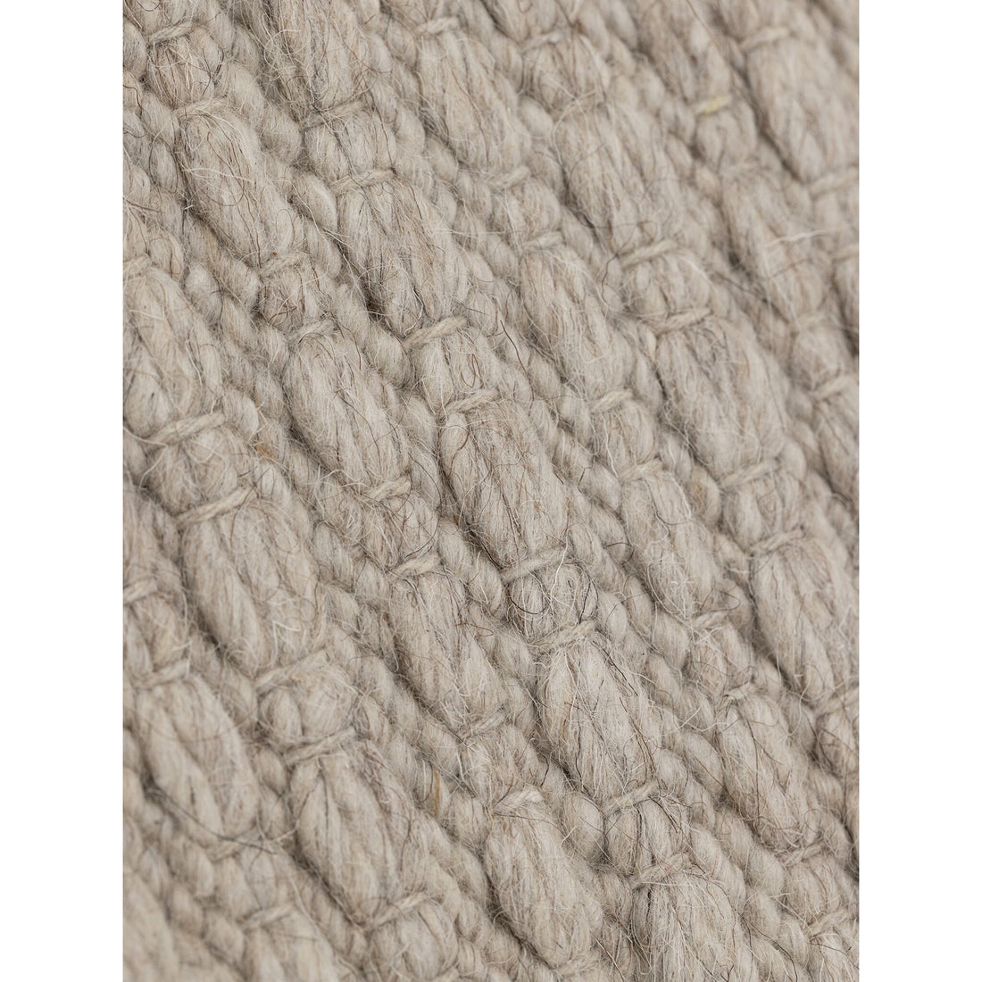 Nirvana vloerkleed van MUST Living in beige, detail van het gevlochten reliëfpatroon in de weving