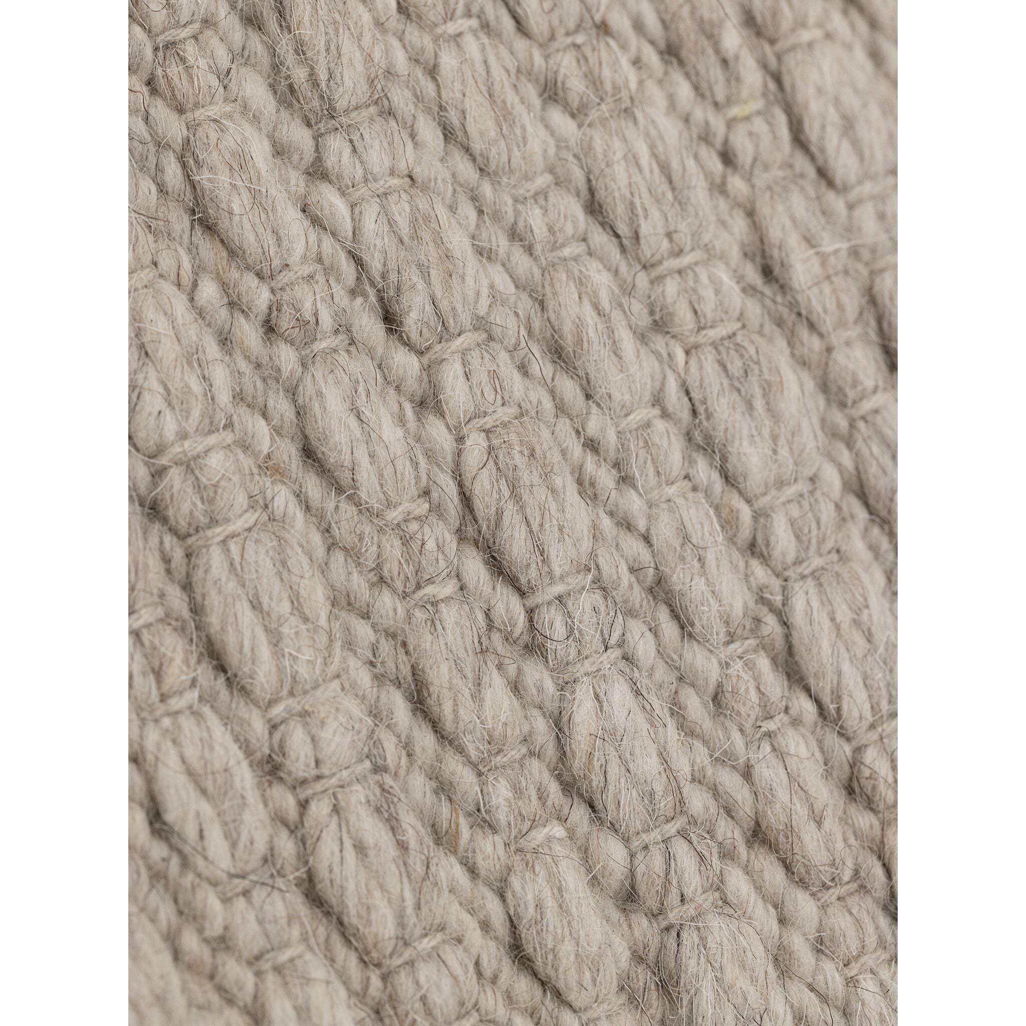 Nirvana vloerkleed van MUST Living in beige, detail van het gevlochten reliëfpatroon in de weving