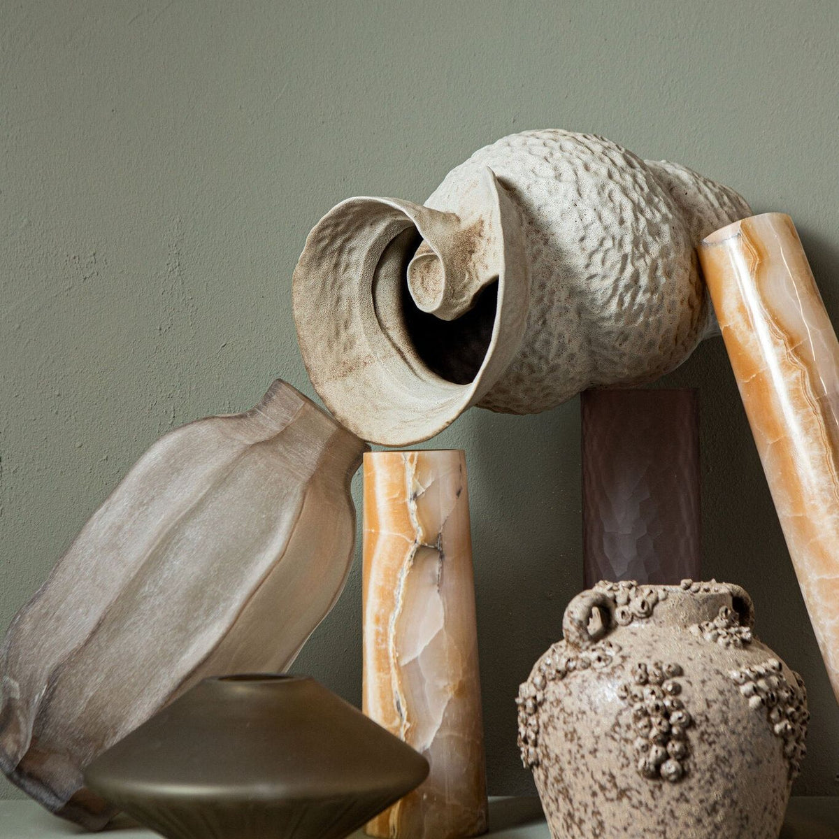 Natae Beige Round Glass Ribbed Vase Low van PTMD in een warm ingerichte woonkamer