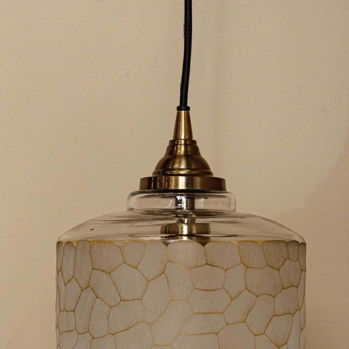 Nore hanglamp small van PTMD in een woonsetting, glazen hanglamp boven een tafel