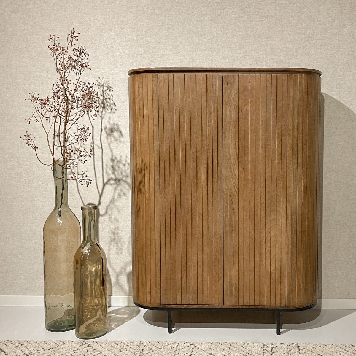 Noor opbergkast in Pecan in een lichte kamer met vazen en droogbloemen