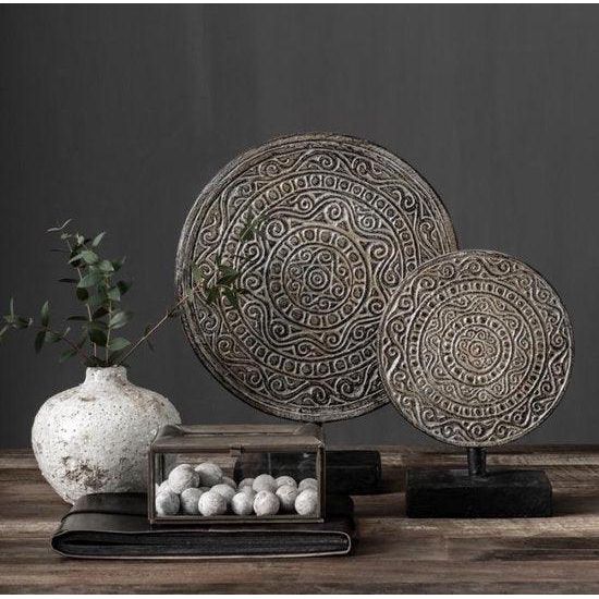 Twee antiek witte ornamenten op voet van MUST Living naast elkaar op een dressoir