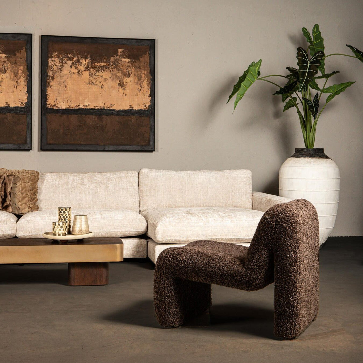 Oslo teddy fauteuil in bruin naast een witte bank en salontafel in een woonkamer