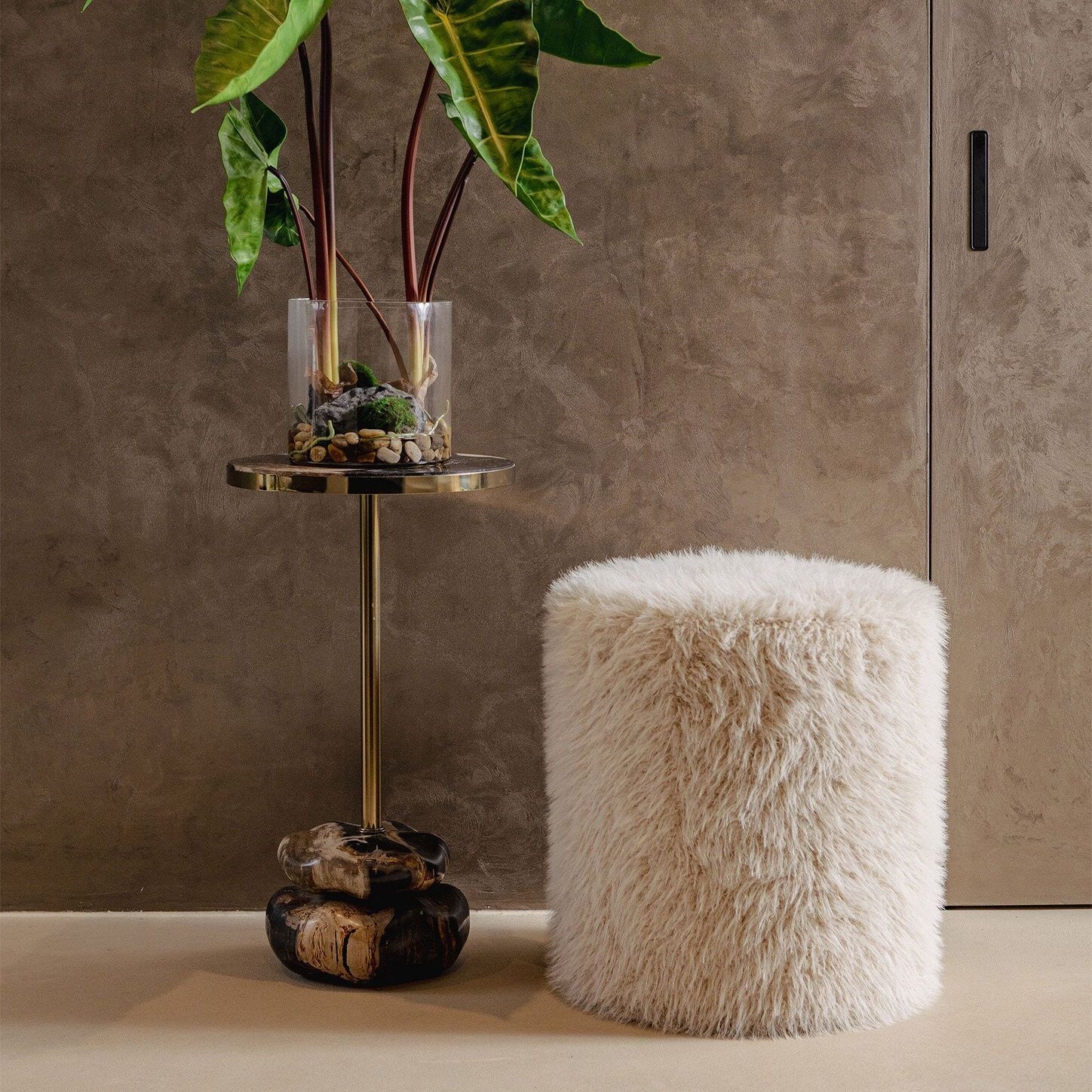 Beige ronde poef van PTMD als voetenbank in een warm interieur met plaid