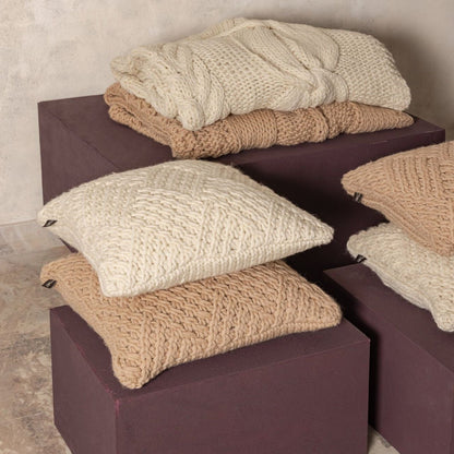 Rama Plaid Wol Handgebreid Crème van PTMD, handgebreide crèmekleurige wollen plaid, tweede sfeerbeeld in een interieur