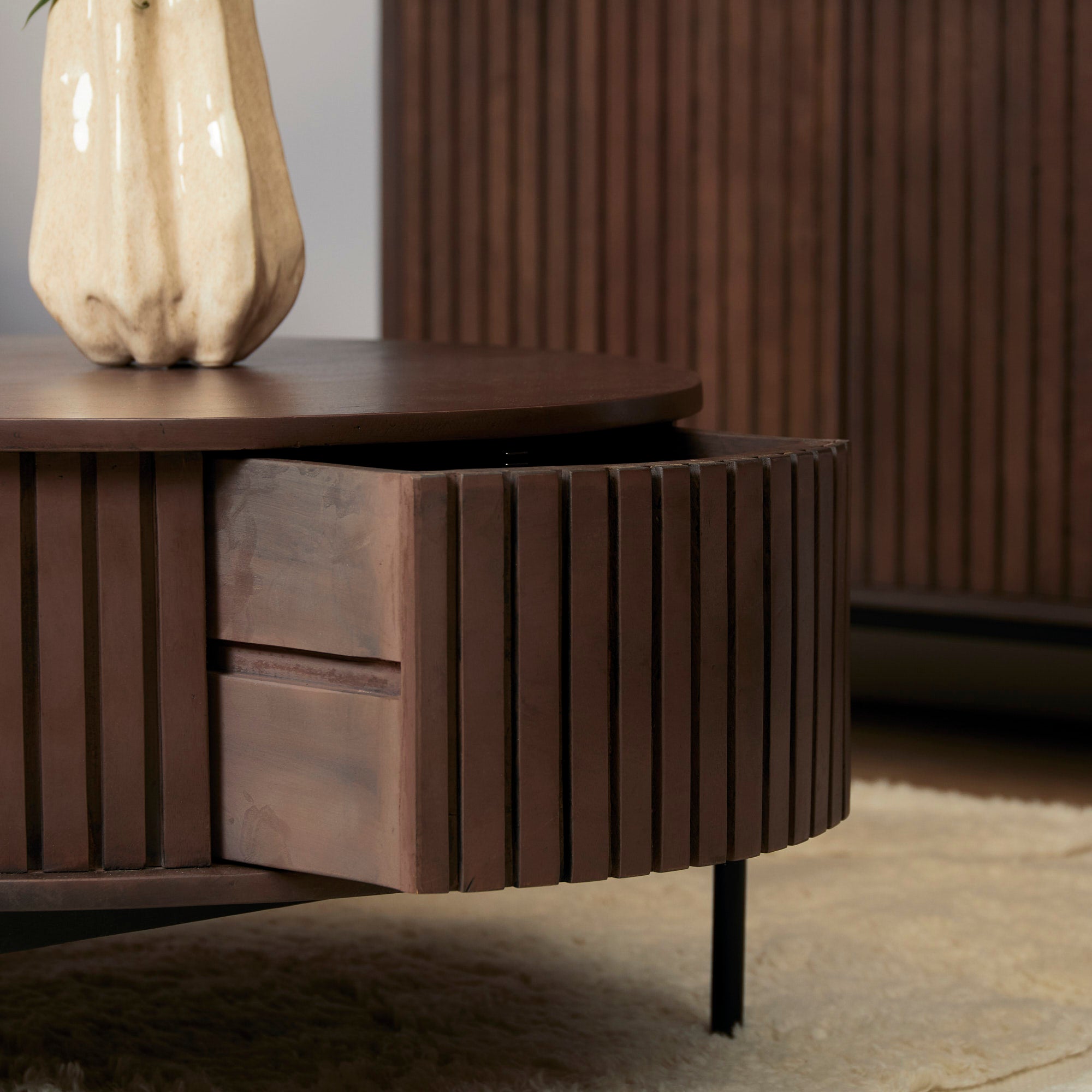 Het zwart metalen onderstel onder de ronde Madison salontafel