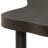 Detail van de ronde poot en de afgeronde bladrand van de espresso Tobago salontafel