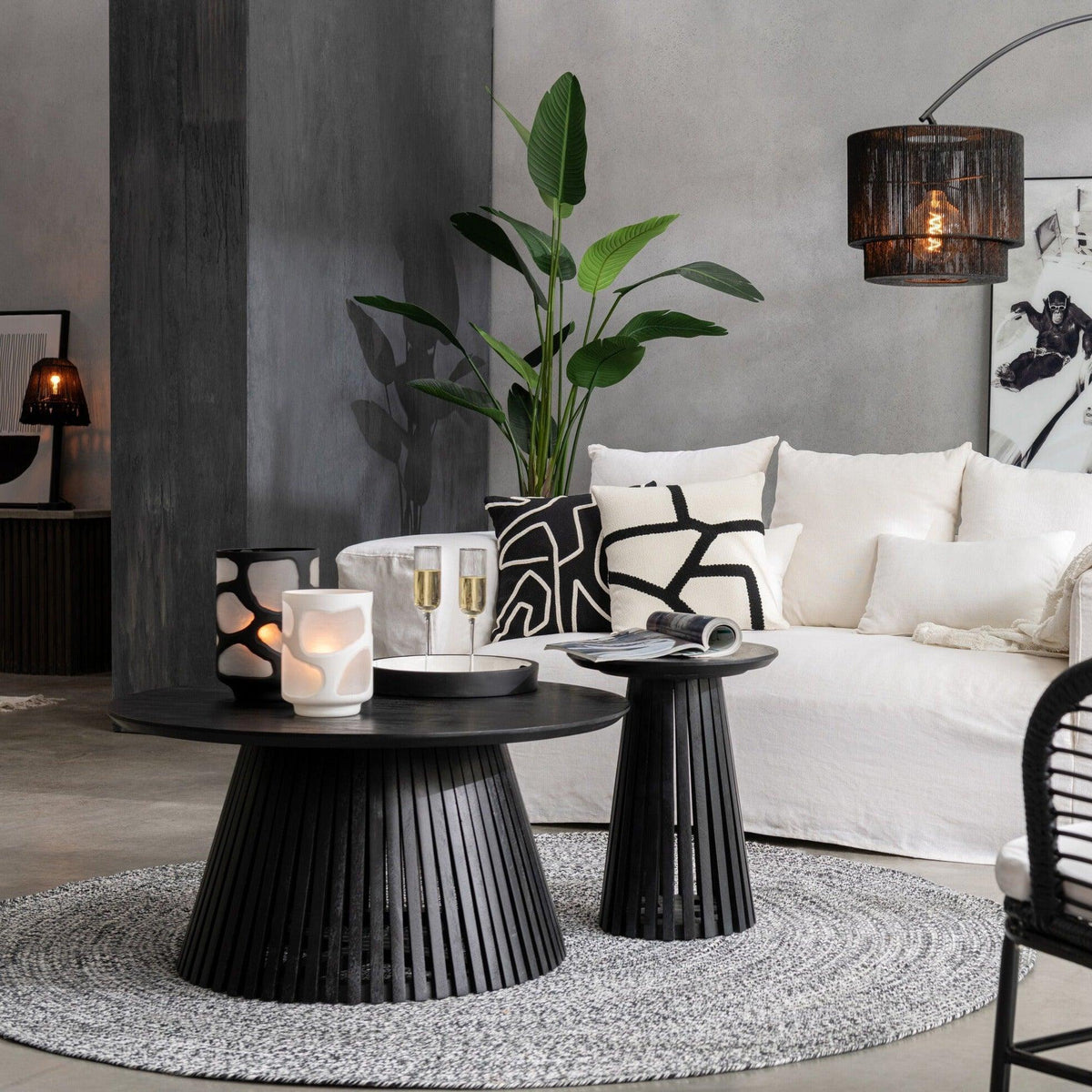 Salontafel Vincent van J-Line in zwart mangohout, gestyled met kaarsen naast de bijzettafel in een lichte woonkamer