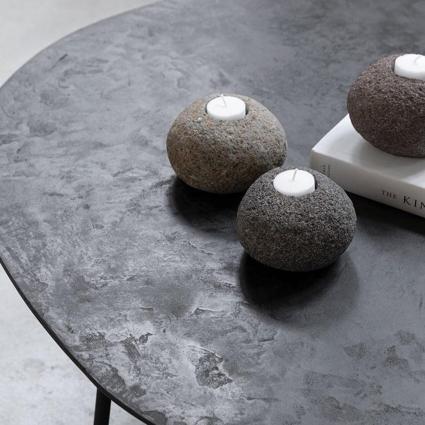 Kandelaars Riverstone van MUST Living met brandende waxinelichtjes op een tafel
