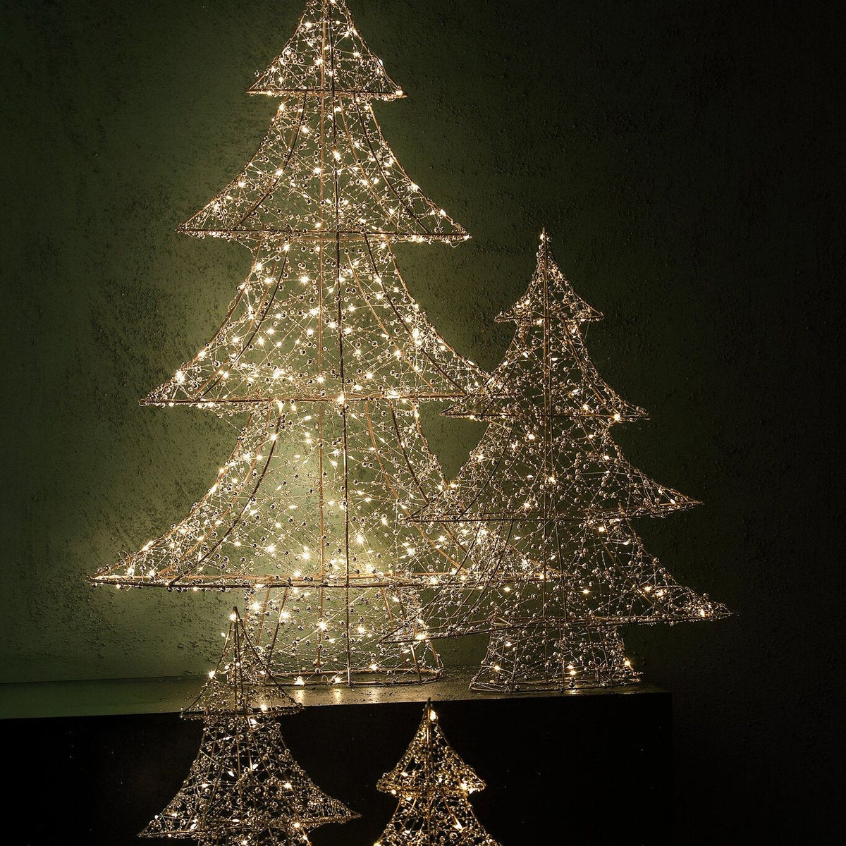 Set Van 3 Misk LED Kerstbomen Goud Met Kralen van PTMD, verlichte kerstbomen met kraaltjes in een donkere kamer