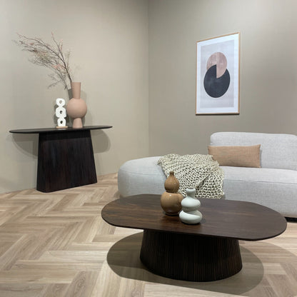 Donkere Salvator sidetable in een woonkamer met bank en ovale salontafel