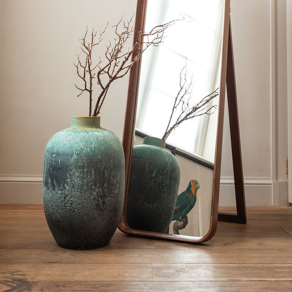 Vintage keramiek vaas azuurblauw in interieur naast staande spiegel