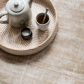 Vloerkleed La Belle van MUST Living, sfeerbeeld van het beige viscose kleed in een lichte woonkamer
