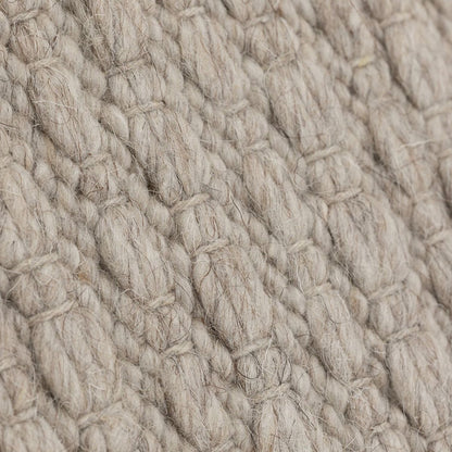 Vloerkleed Nirvana van MUST Living, detailfoto van de dikke gevlochten wolstructuur in beige