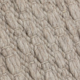 Vloerkleed Nirvana van MUST Living, detailfoto van de dikke gevlochten wolstructuur in beige