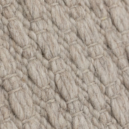 Vloerkleed Nirvana van MUST Living, detailfoto van de dikke gevlochten wolstructuur in beige