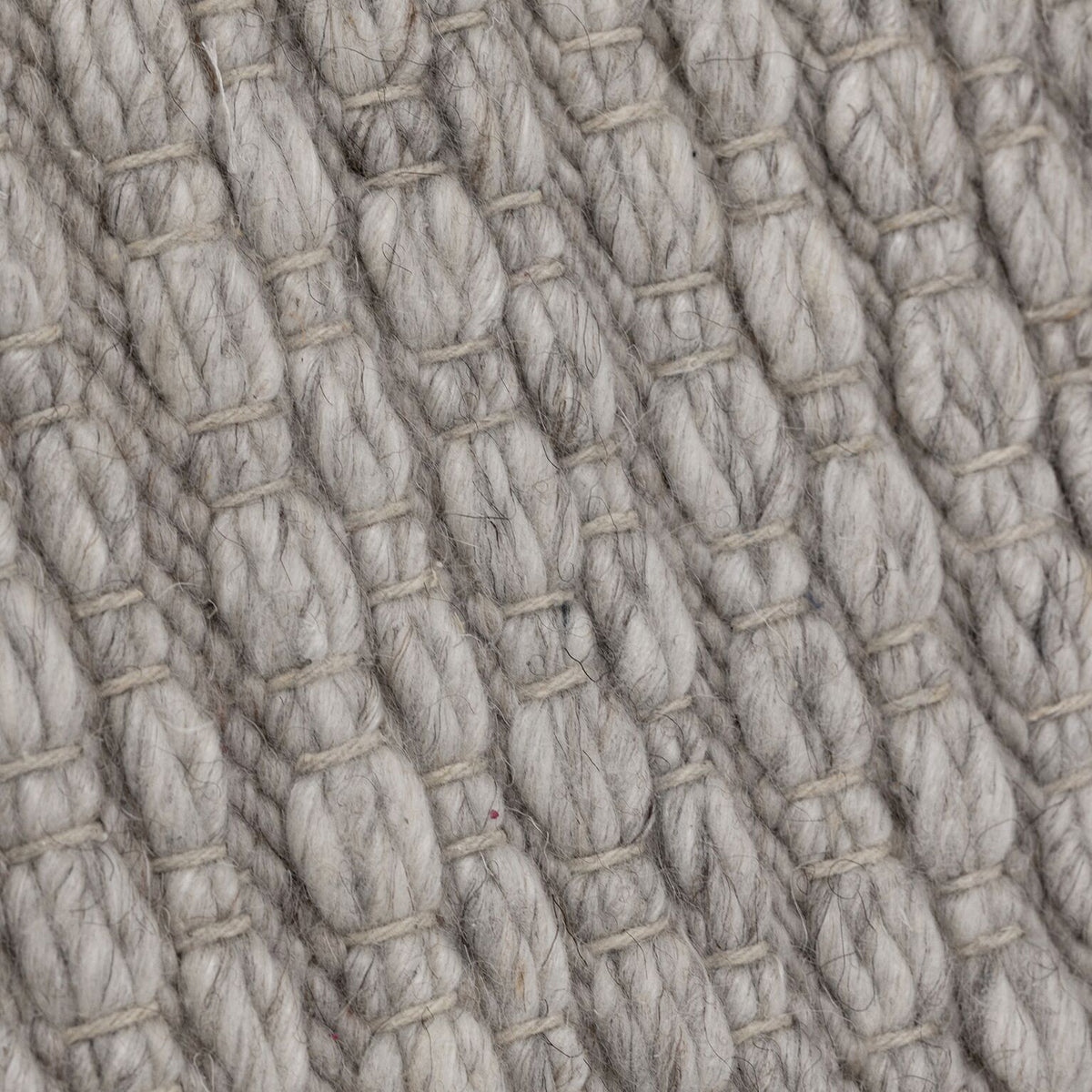 Detail van het grijze Nirvana vloerkleed van MUST Living met zichtbare wolvezels