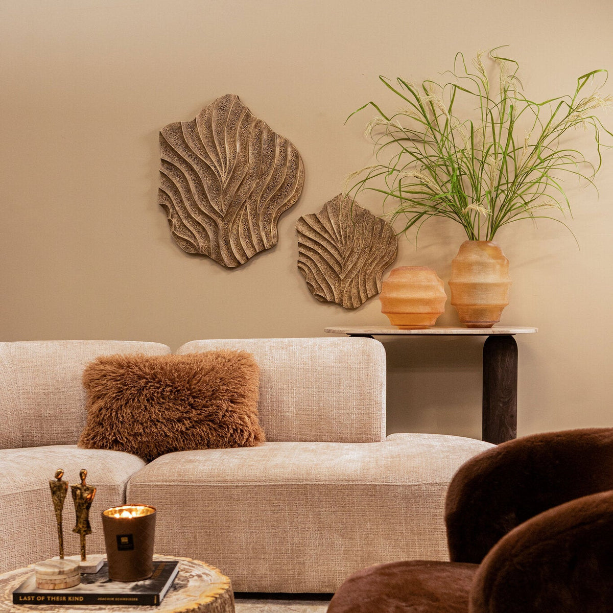 Wandcompositie met Abbie panelen van PTMD in een warme zithoek met boomstam salontafel